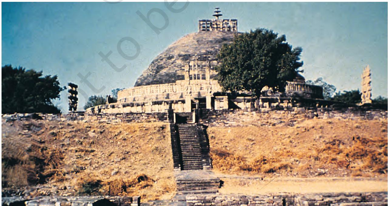 Fig. 4.3
The Great Stupa at Sanchi
If you travel from Delhi to Bhopal by train, you will see the majestic stupa complex on top of a hill, crowning it as it were. If you request the guard he will stop the train at the little station of Sanchi for two minutes – enough time for you to get down. As you climb up the hill you can see the complex of structures: a large mound and other monuments including a temple built in the fifth century.